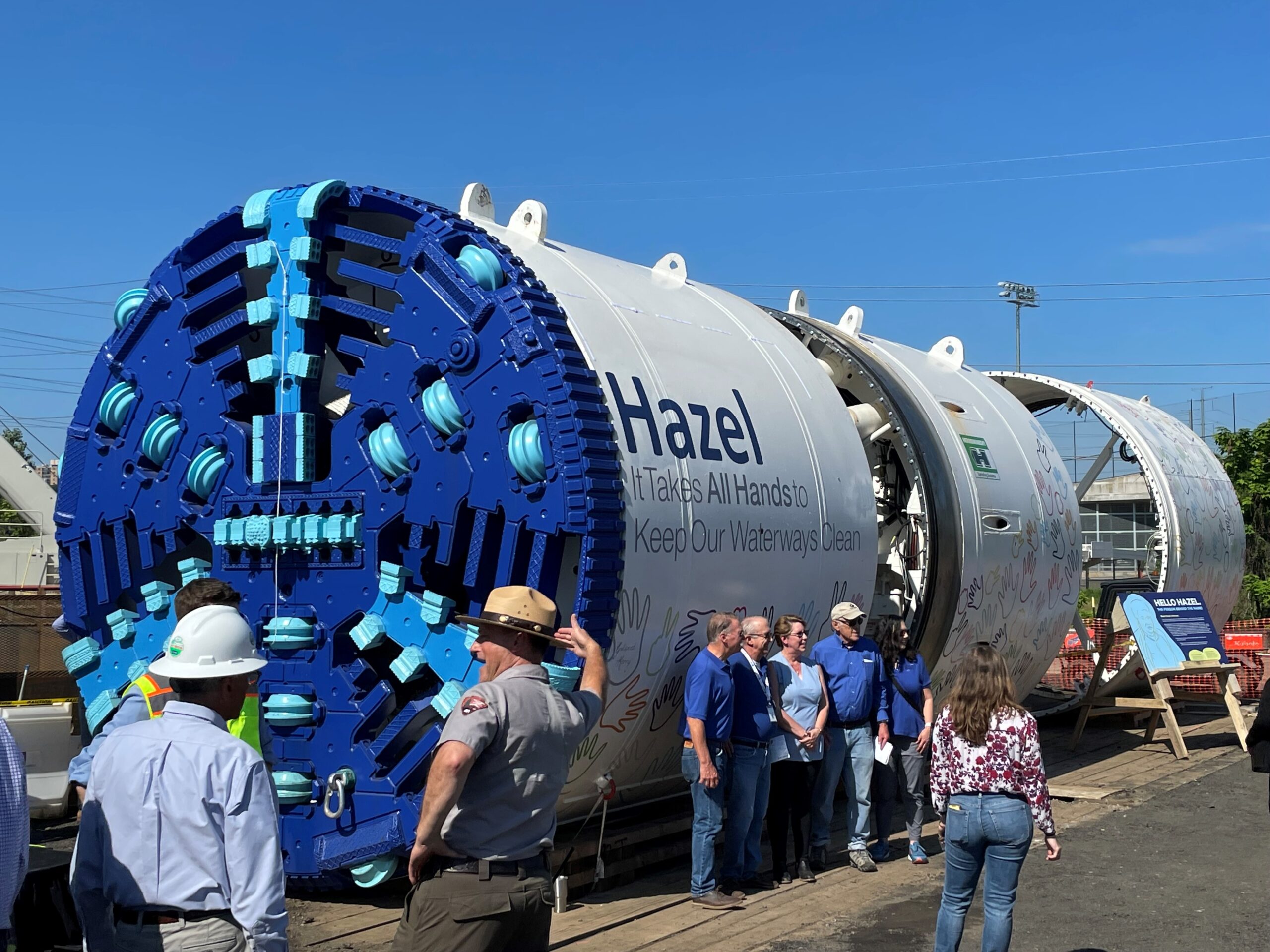 Hazel It takes all hands to keep our water ways clean, with people posing in front of the tunnel piping